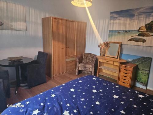 a bedroom with a bed with a blue blanket with stars on it at Serenity Big Room in Brussels
