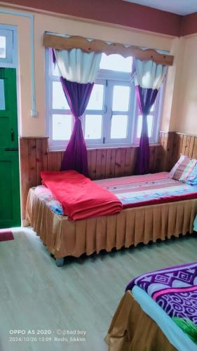a bedroom with two beds with purple drapes at Rishop Mountain Homestay in Rishop