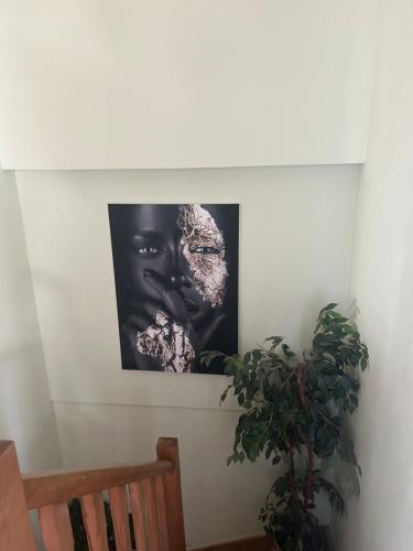 a black and white picture on a wall with a plant at Serenity Big Room in Brussels