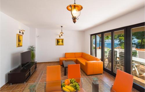 a living room with orange chairs and a couch at 2 Bedroom Awesome Home In Stomorska in Stomorska