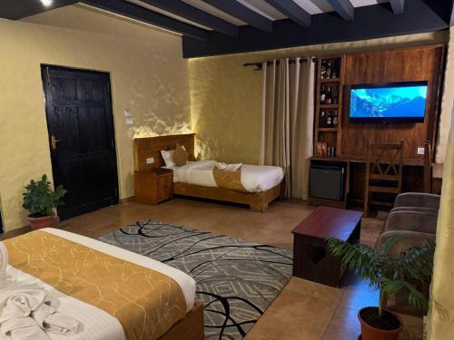 una camera d'albergo con un letto e una televisione di Annapurna Boutique Hotel a Pokhara