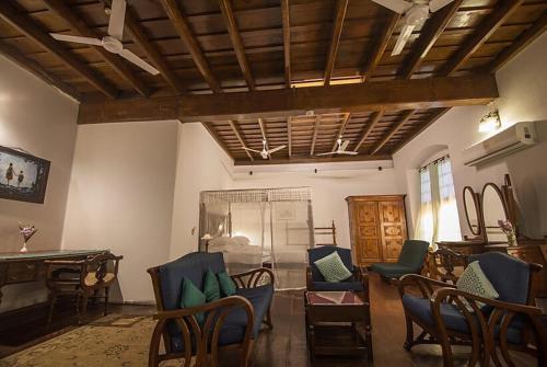 a living room with blue chairs and a table at Old Courtyard Hotel in Cochin