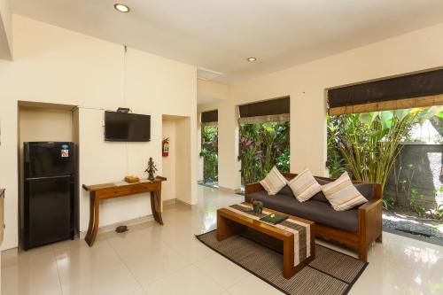 a living room with a couch and a table at Kadiga Villas Ubud by GenuineHost in Ubud