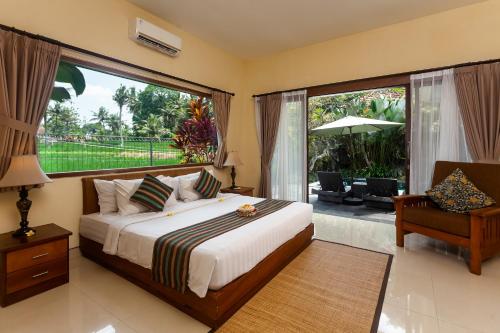 a bedroom with a bed and a large window at Kadiga Villas Ubud by GenuineHost in Ubud