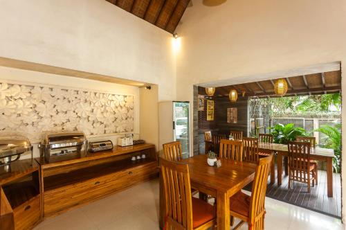 a kitchen and dining room with a wooden table and chairs at Kadiga Villas Ubud by GenuineHost in Ubud