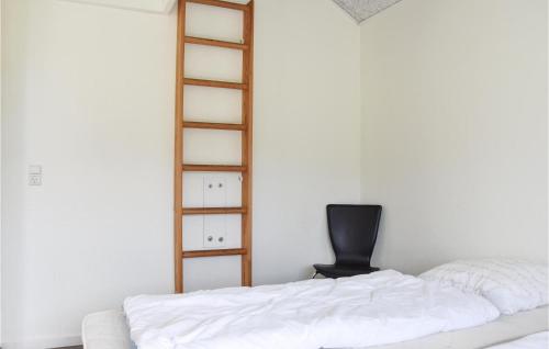 a bedroom with a white bed and a chair at Holiday Home Halvejen Hytte Spjald in Spjald