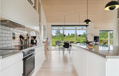a kitchen with white countertops and a dining room at Three-Bedroom Holiday Home In Fjerritslev in Slettestrand