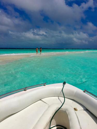 a boat in the water with two people on the beach at Faza View Inn, Maafushi in Maafushi