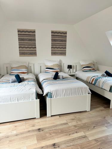 3 lits dans une chambre dotée de murs blancs et de parquet dans l'établissement Cigognes et Bretzel - BARR - 5 guests, à Barr