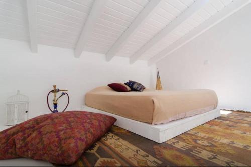 Un dormitorio con una cama en una habitación blanca. en Casa da Nora, en Silves