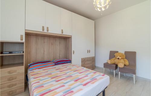 a bedroom with a bed with a teddy bear sitting on a chair at Stunning Apartment In Recco With Wifi in Recco