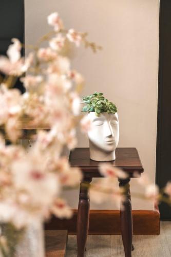 a white vase sitting on a table with flowers at Hermanus Reefs in Hermanus