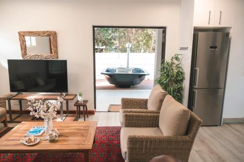 a living room with a tv and a couch and a table at Hermanus Reefs in Hermanus