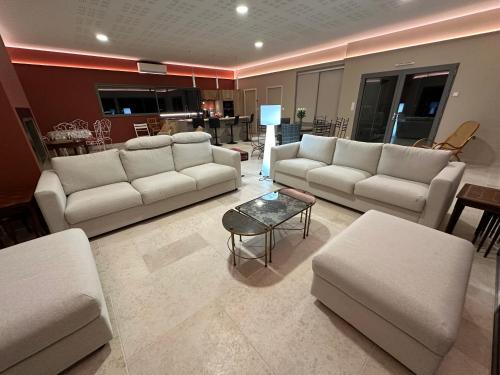 un salon avec des canapés blancs et une table dans l'établissement La maison d'Armelle, à Selommes