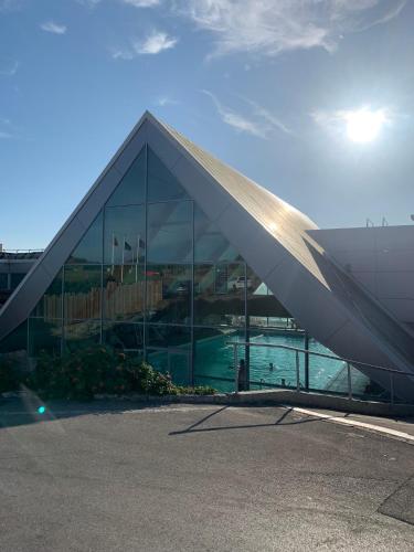 un grand bâtiment en verre avec une piscine en face de celui-ci dans l'établissement La Maison Vintage à Montreuil sur mer 3 Chambres - Jardin - 6 personnes - Wifi, à Neuville-sous-Montreuil