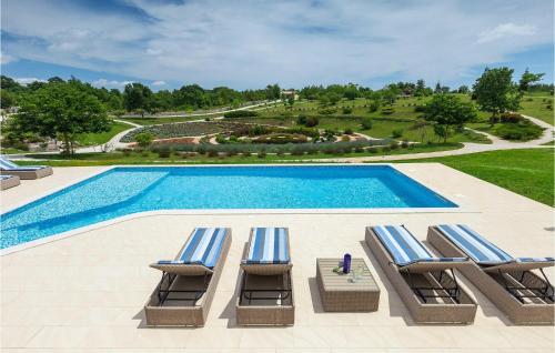a group of lounge chairs next to a swimming pool at Villa Arkaim in Pula