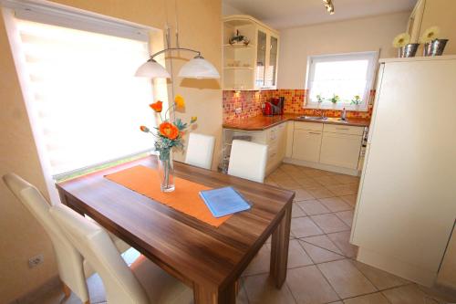 a kitchen with a wooden table with a vase of flowers on it at Ferienhaus Sonnenschein in Neu Gaarz
