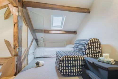 a attic room with a chair and a bed at Sedbergh Penthouse - KingBed - Tv - Wifi in Sedbergh