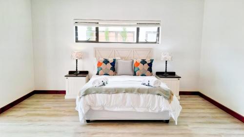 a bedroom with a white bed with two night stands at Hermanus Reefs in Hermanus