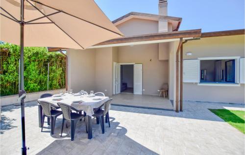 a patio with a table and chairs and an umbrella at 3 Bedroom Cozy Home In Piano Di Mommio in Piano di Mommio