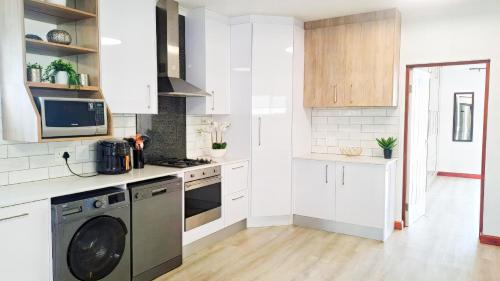 a kitchen with white cabinets and a dishwasher at Hermanus Reefs in Hermanus