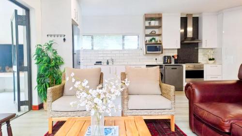 a living room with two chairs and a table at Hermanus Reefs in Hermanus