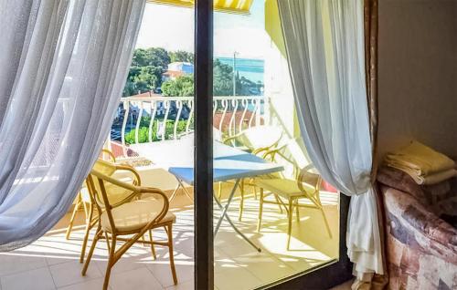 a room with a balcony with a table and chairs at Stunning Apartment In Krk With Wifi in Krk