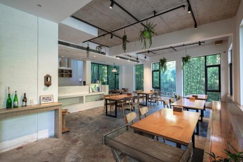 a dining room with tables and chairs and windows at Vretreats yunxishang Boutique Hotel in Deqing