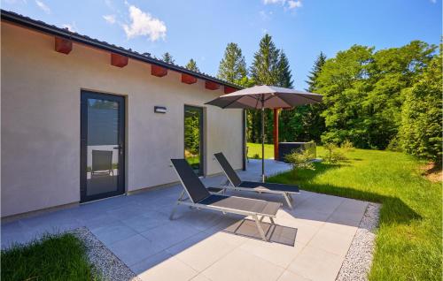 two lounge chairs and an umbrella on a patio at Wellness House By The Lake in Trakoščansko Jezero