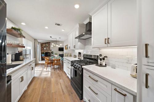 a kitchen with white cabinets and a black stove top oven at Nr The Woodlands Houston Retreat Yard Bbq Games in Spring