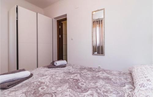 a white room with a bed and a mirror at Awesome Home In Valbandon in Štinjan