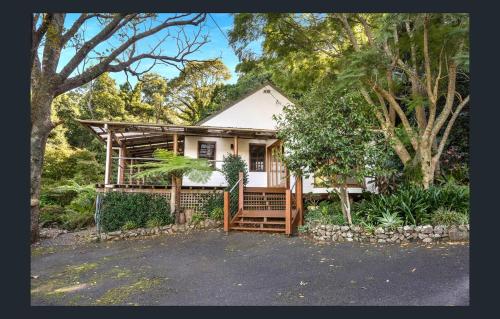 a small house with a porch in the woods at Hinterland Retreat on 30 acres - Sleeps 6 in Broughton Village