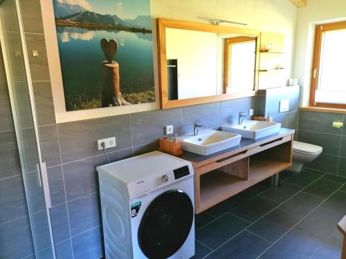 a bathroom with two sinks and a washing machine at Ferienwohnung Lacken in Fieberbrunn