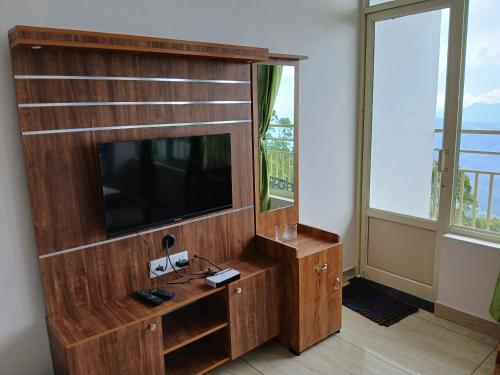 a large wooden entertainment center with a flat screen tv at Sky Elanza in Munnar