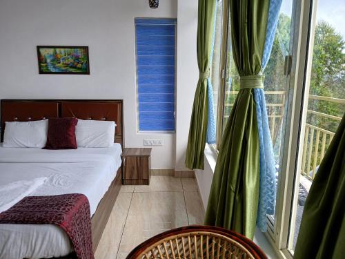 a bedroom with a bed and a large window at Sky Elanza in Munnar