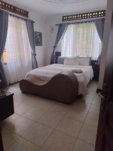 a large bedroom with a large bed with windows at SKA the boutique b&b in Kampala