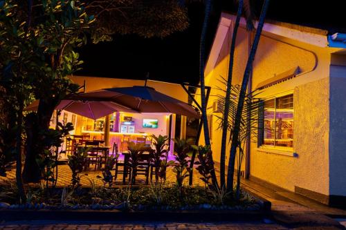 a patio with tables and umbrellas at night at SKA the boutique b&b in Kampala