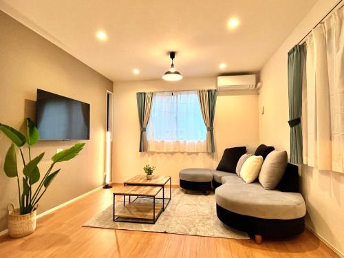 a living room with a couch and a table at Casa Stella 6 by Liaison in Osaka