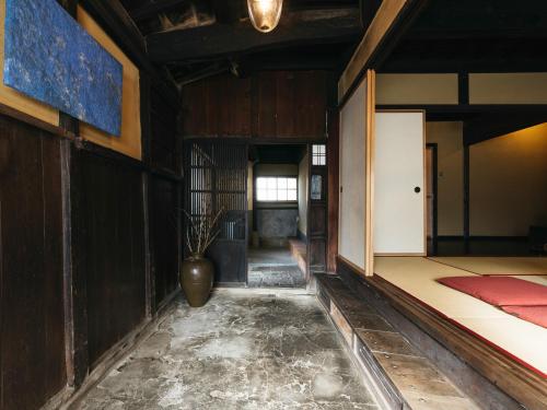 a hallway with a vase in the middle of a room at RITA Izumo Sagiura in Izumo