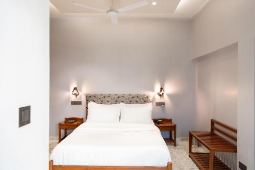 a bedroom with a large white bed with two tables at Girisadan Boutique Stay in Jaipur
