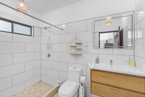a white bathroom with a toilet and a sink at Casa Verde 2b2b Completely Renovated Ground Unit in Coco