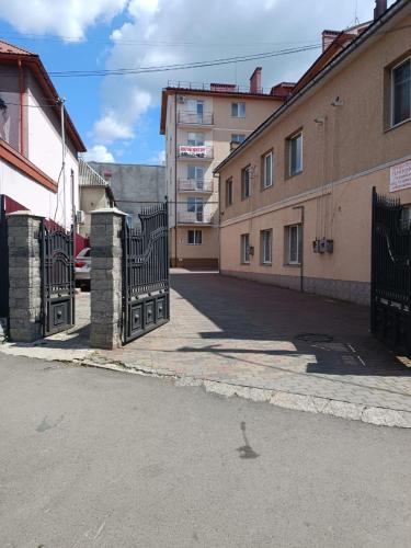 an empty street with a gate and buildings at Apartments Domovik on Beregovskaya 3 in Mukacheve