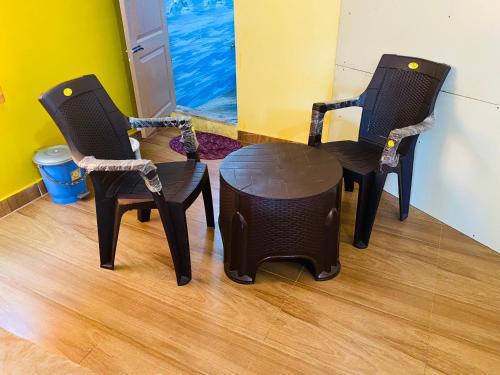 two chairs and a table in a room at Vibe n rejoice in Ooty