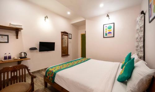 a bedroom with a bed and a tv on the wall at Treebo Kashvijoy, 7 Km From Kamakhya Temple in Guwahati