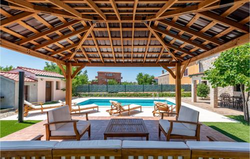 ヴィルにあるLovely Home In Vir With Wifiの木製パーゴラとプール付きのパティオ