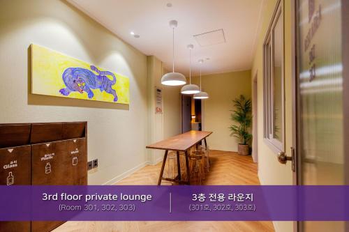 a room with a table and a painting on the wall at Hostel Mihojae Incheon in Incheon