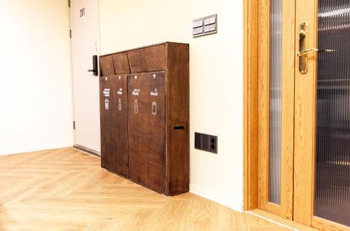 a brown locker in a room with a wooden floor at Hostel Mihojae Incheon in Incheon