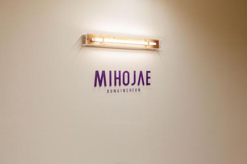 a sign on a wall with a light on it at Hostel Mihojae Incheon in Incheon