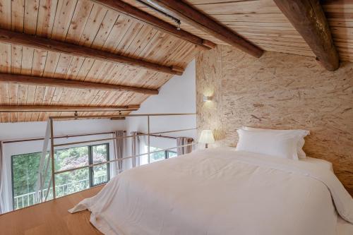 a bedroom with a white bed and a window at Vretreats yunxishang Boutique Hotel in Deqing