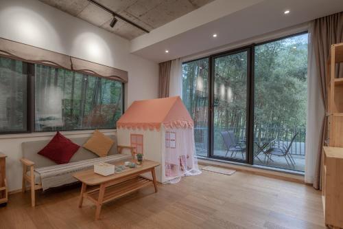 a living room with a couch and a large window at Vretreats yunxishang Boutique Hotel in Deqing